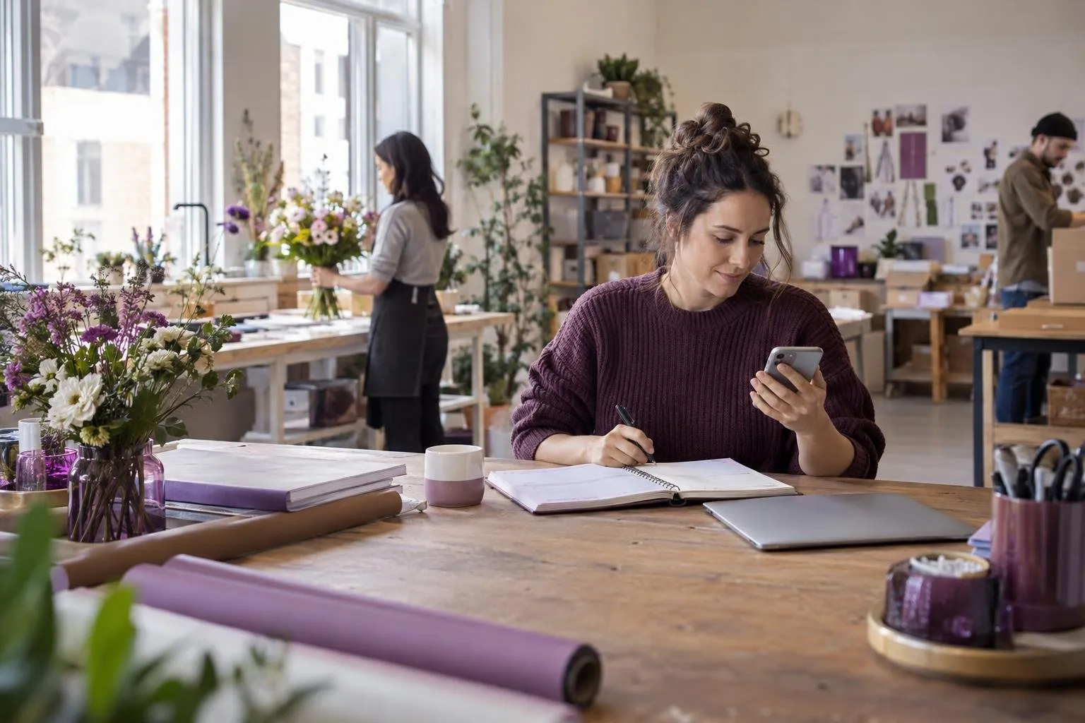 Travailleuse autonome au bureau avec outils de suivi et téléphone