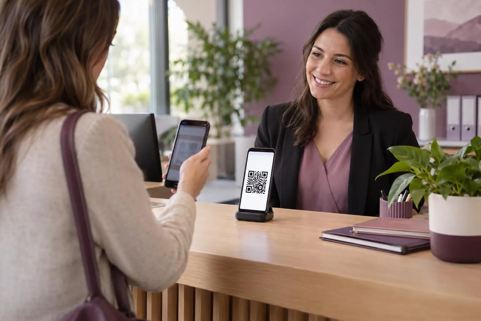 Téléphone affichant un code QR à l’accueil d’une petite entreprise, lu par une visiteuse